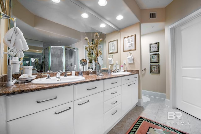 bathroom with tile floors, dual bowl vanity, and an enclosed shower