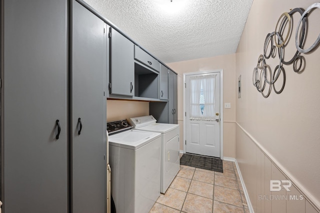 clothes washing area featuring independent washer and dryer, cabinets, light tile patterned floors, and a textured ceiling