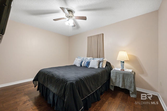 bedroom with ceiling fan, a textured ceiling, and dark hardwood / wood-style flooring