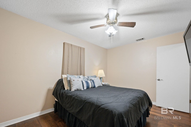 bedroom featuring dark hardwood / wood-style floors, a textured ceiling, and ceiling fan