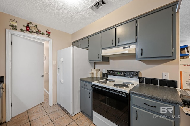 kitchen featuring a textured ceiling, light tile patterned floors, white appliances, and gray cabinetry