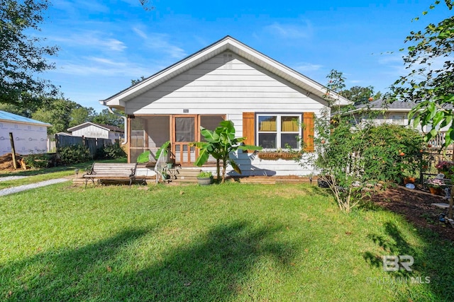 back of property featuring a yard and a sunroom