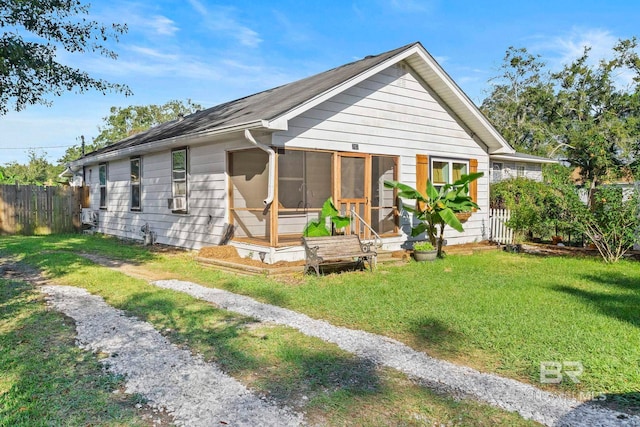 view of front of home with a sunroom and a front lawn