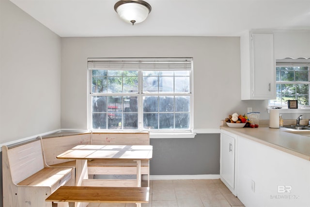 unfurnished dining area featuring sink, plenty of natural light, and light tile patterned floors