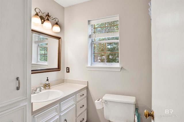 bathroom with plenty of natural light, vanity, and toilet