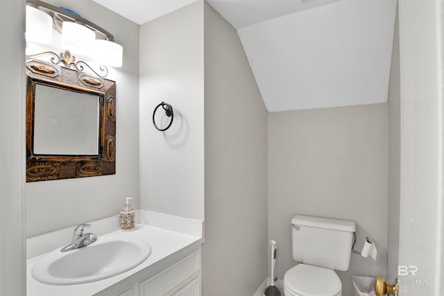 bathroom featuring vaulted ceiling, toilet, and vanity