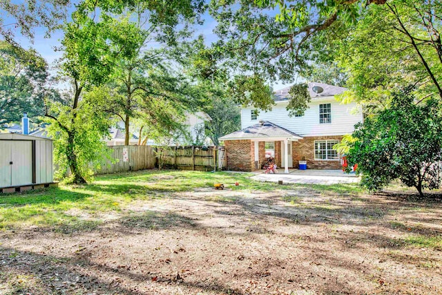 view of yard featuring a patio and a storage shed