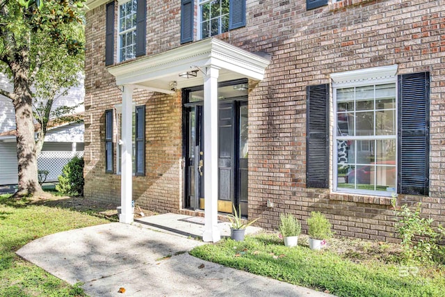 doorway to property featuring brick siding