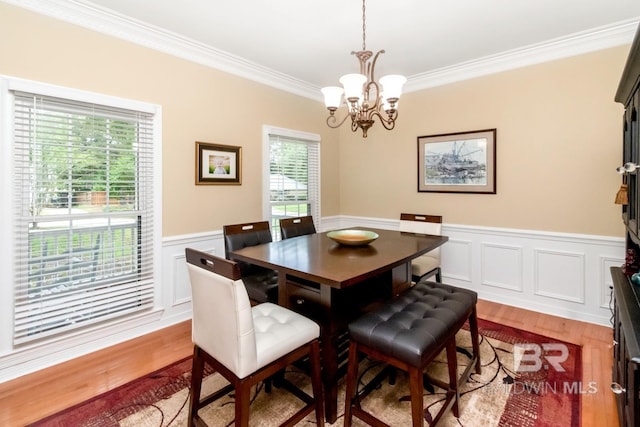 1509 Ridgeland Rd, Mobile, AL 36695 - dining area with a chandelier, ornamental molding, wood finished floors, a wainscoted wall, and a decorative wall