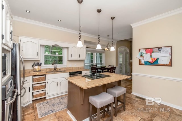 1509 Ridgeland Rd, Mobile, AL 36695 - kitchen with a center island, a kitchen bar, ornamental molding, white cabinetry, and stainless steel appliances