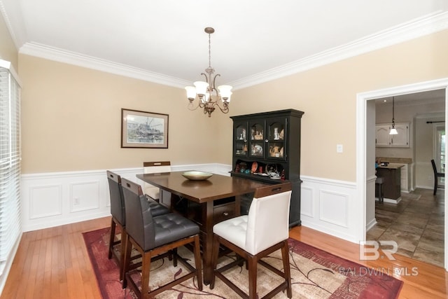 1509 Ridgeland Rd, Mobile, AL 36695 - dining space featuring a chandelier, crown molding, wainscoting, wood finished floors, and a decorative wall