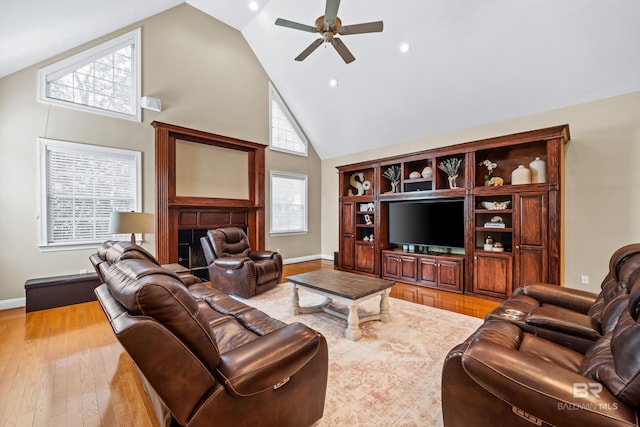 living room featuring ceiling fan, light hardwood / wood-style flooring, and high vaulted ceiling