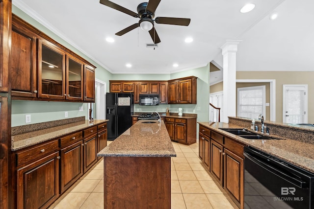 kitchen featuring a center island, sink, black appliances, light tile patterned floors, and ornate columns