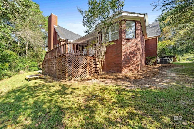 back of property featuring a lawn and a deck