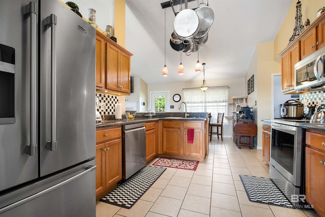 2856 W Saddlebrook Dr, Mobile, AL 36695 - kitchen with a peninsula, dark countertops, brown cabinetry, and stainless steel appliances