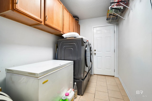 2856 W Saddlebrook Dr, Mobile, AL 36695 - laundry area featuring a textured ceiling, light tile patterned flooring, washer and dryer, cabinet space, and baseboards