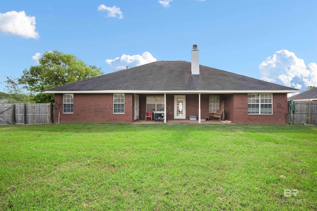 2856 W Saddlebrook Dr, Mobile, AL 36695 - rear view of house with a fenced backyard, brick siding, a chimney, and a patio