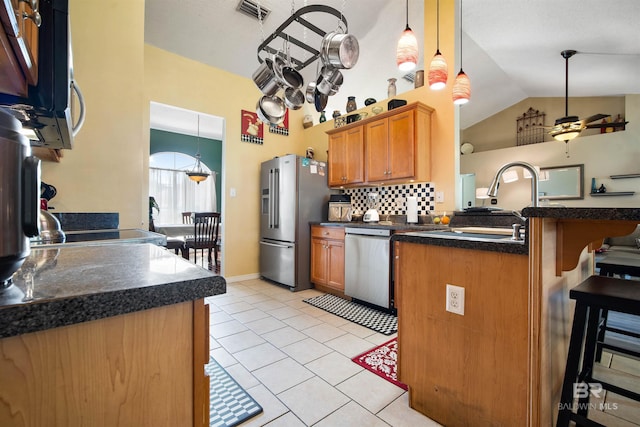 2856 W Saddlebrook Dr, Mobile, AL 36695 - kitchen with a peninsula, a kitchen bar, dark countertops, and stainless steel appliances
