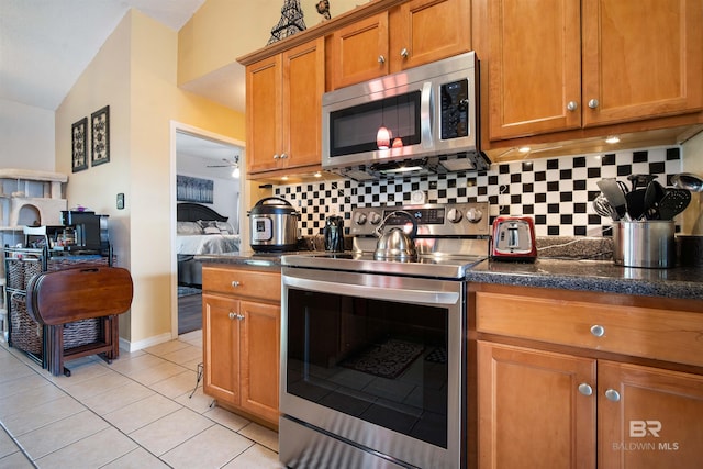 2856 W Saddlebrook Dr, Mobile, AL 36695 - kitchen with backsplash, brown cabinetry, stainless steel appliances, and light tile patterned floors