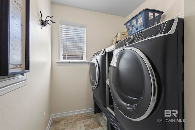 laundry room featuring laundry area, light tile patterned floors, separate washer and dryer, and baseboards