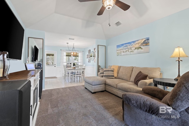 living area with tile patterned floors, visible vents, carpet flooring, ceiling fan, and vaulted ceiling