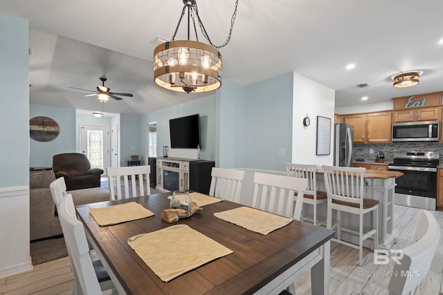 dining space with light wood-style flooring, recessed lighting, ceiling fan with notable chandelier, and visible vents