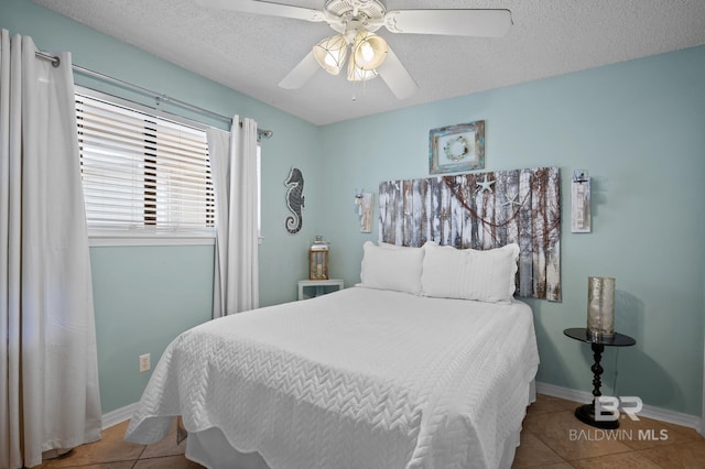 tiled bedroom featuring a textured ceiling, ceiling fan, and baseboards