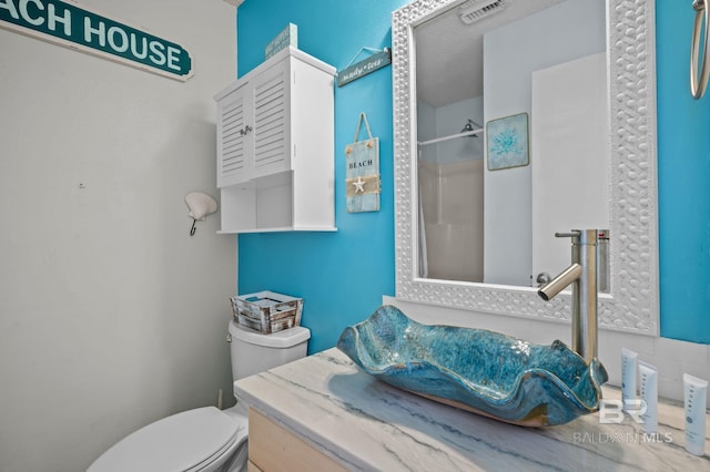 full bath featuring toilet, a shower, and vanity