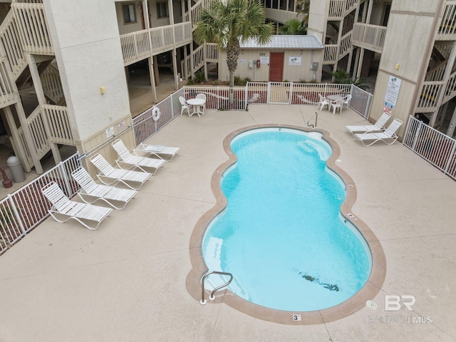 community pool featuring fence and a patio
