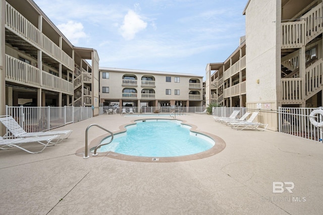community pool with fence and a patio