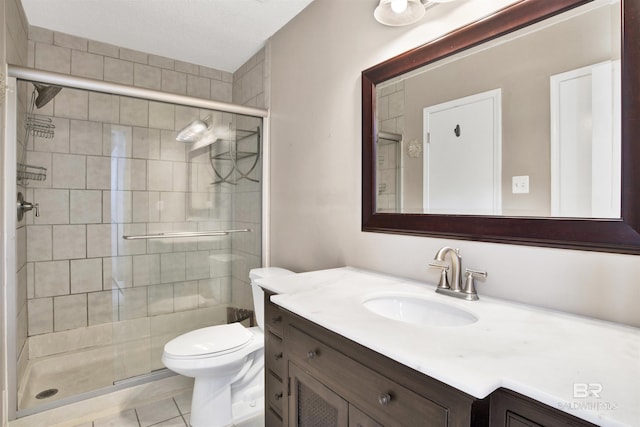 bathroom featuring a shower with door, vanity, tile patterned floors, and toilet