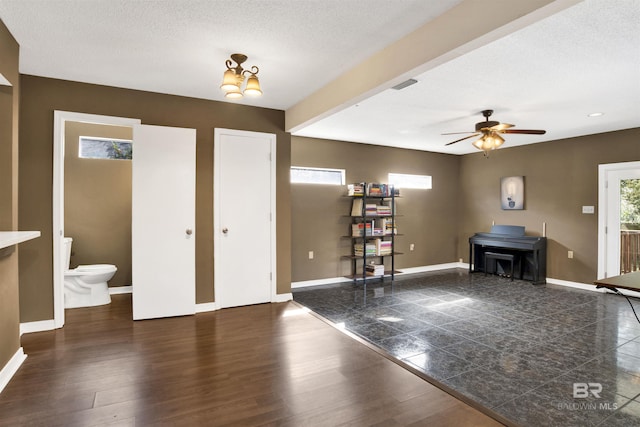 foyer entrance featuring ceiling fan, dark hardwood / wood-style floors, and a textured ceiling