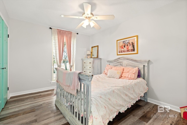 bedroom with a ceiling fan, baseboards, and wood finished floors