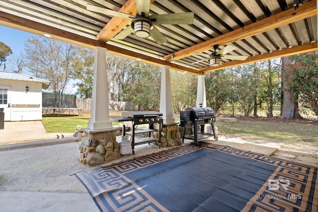 view of patio with a trampoline, area for grilling, a fenced backyard, and a ceiling fan