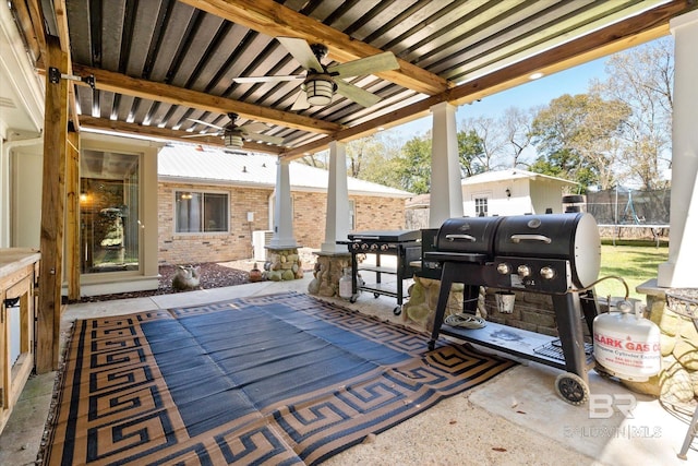 view of patio / terrace featuring a trampoline, a grill, a ceiling fan, and fence