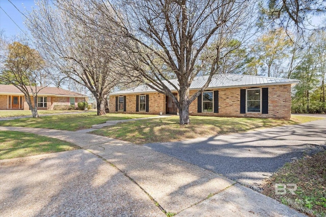 single story home with a front lawn and brick siding