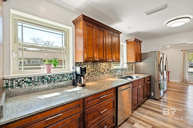 kitchen with tasteful backsplash, visible vents, light wood-type flooring, appliances with stainless steel finishes, and a sink