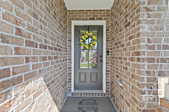 doorway to property featuring brick siding