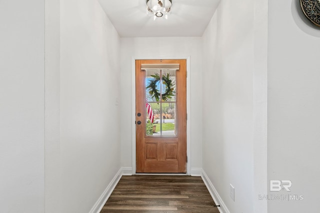 doorway featuring baseboards and dark wood-style flooring