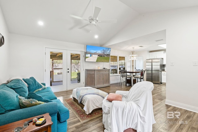 living area with french doors, lofted ceiling, light wood-style floors, and baseboards