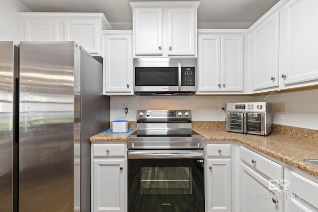 kitchen featuring white cabinetry, a toaster, light stone countertops, and stainless steel appliances