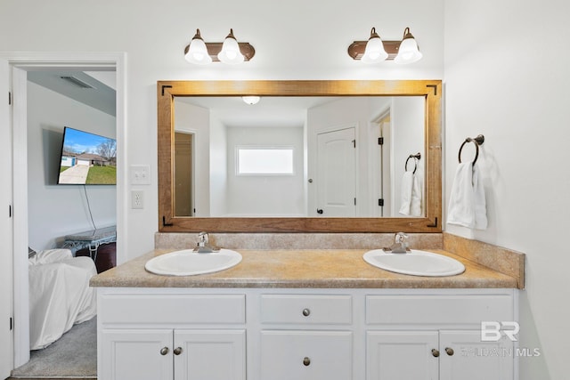 full bath featuring double vanity, visible vents, connected bathroom, and a sink