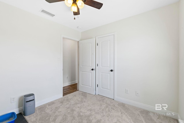 unfurnished bedroom with visible vents, baseboards, a ceiling fan, and carpet flooring