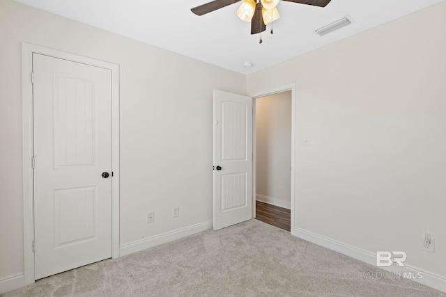 unfurnished bedroom featuring visible vents, ceiling fan, baseboards, and carpet