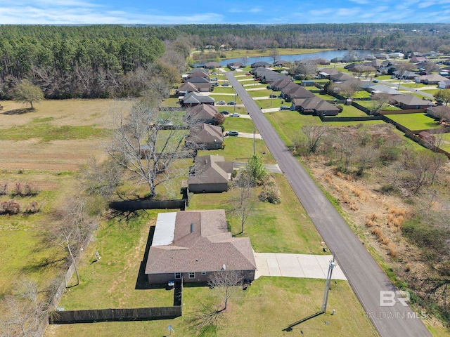 drone / aerial view with a residential view, a forest view, and a water view