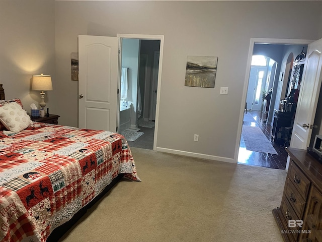 carpeted bedroom featuring ensuite bath