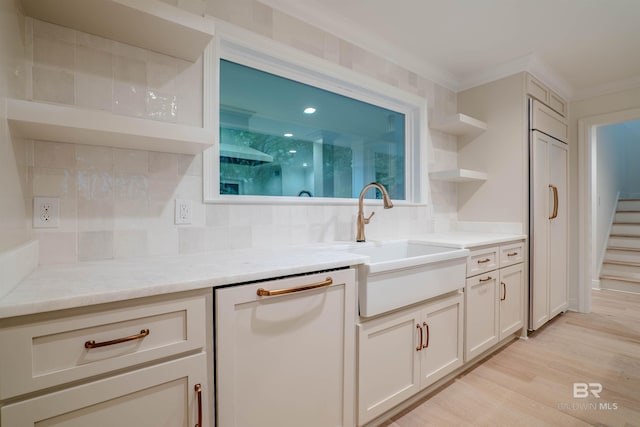 kitchen featuring dishwasher, light hardwood / wood-style floors, decorative backsplash, and sink