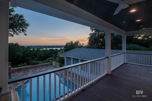 pool at dusk with ceiling fan