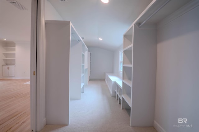 spacious closet with light carpet and lofted ceiling