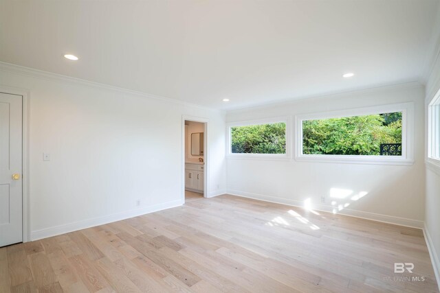 spare room with light hardwood / wood-style floors and crown molding